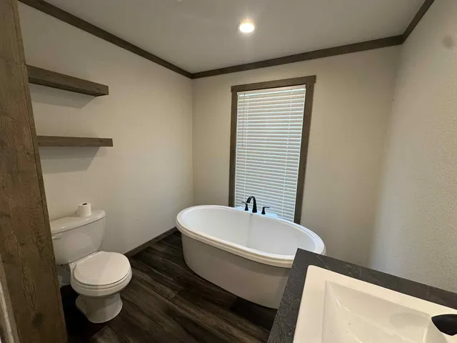 a bathroom with a toilet a sink and mirror