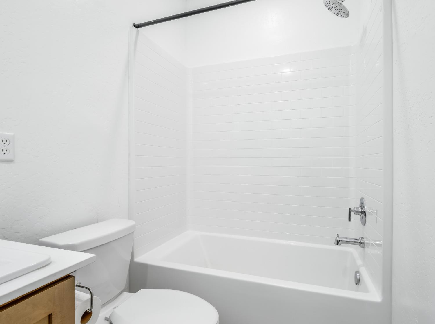 2734 East Teaberry Drive Fresno, CA 93730 - Photo 22 of 34 a white bath tub sitting next to a white toilet