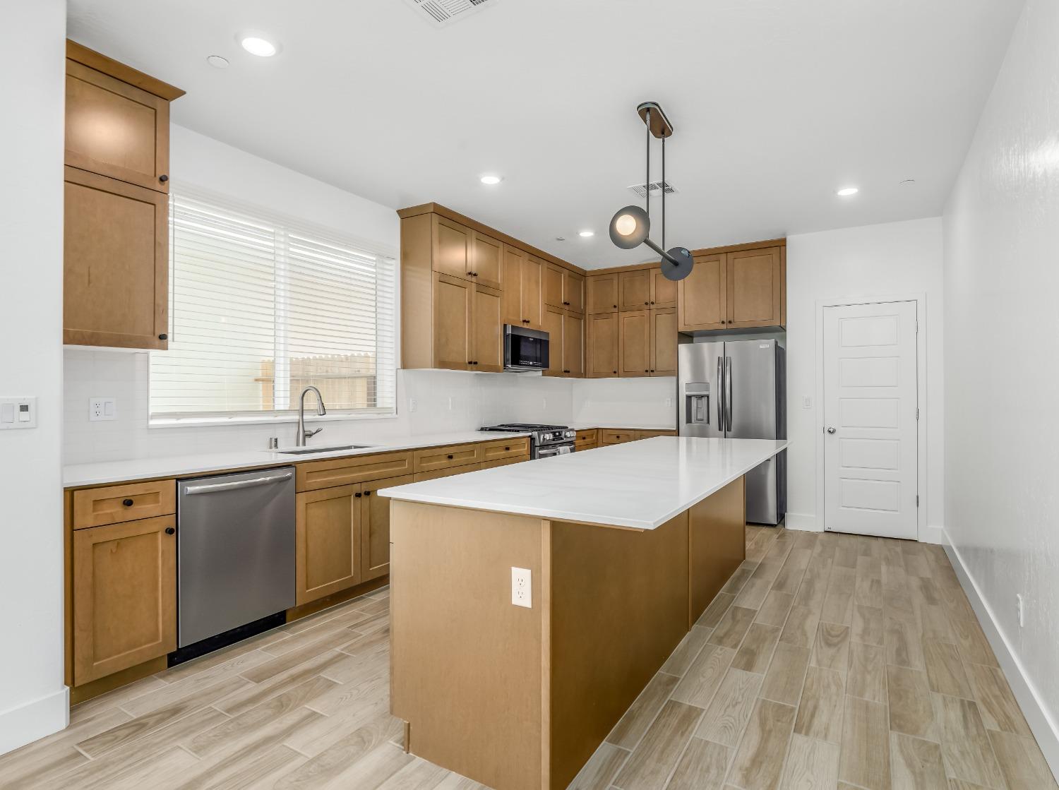 2734 East Teaberry Drive Fresno, CA 93730 - Photo 7 of 34 a large kitchen with stainless steel appliances granite countertop a sink a stove and a refrigerator