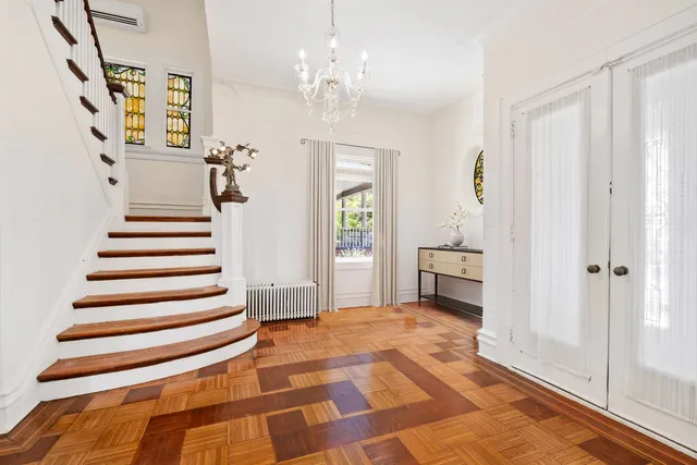 a view of a hallway with wooden floor and staircase