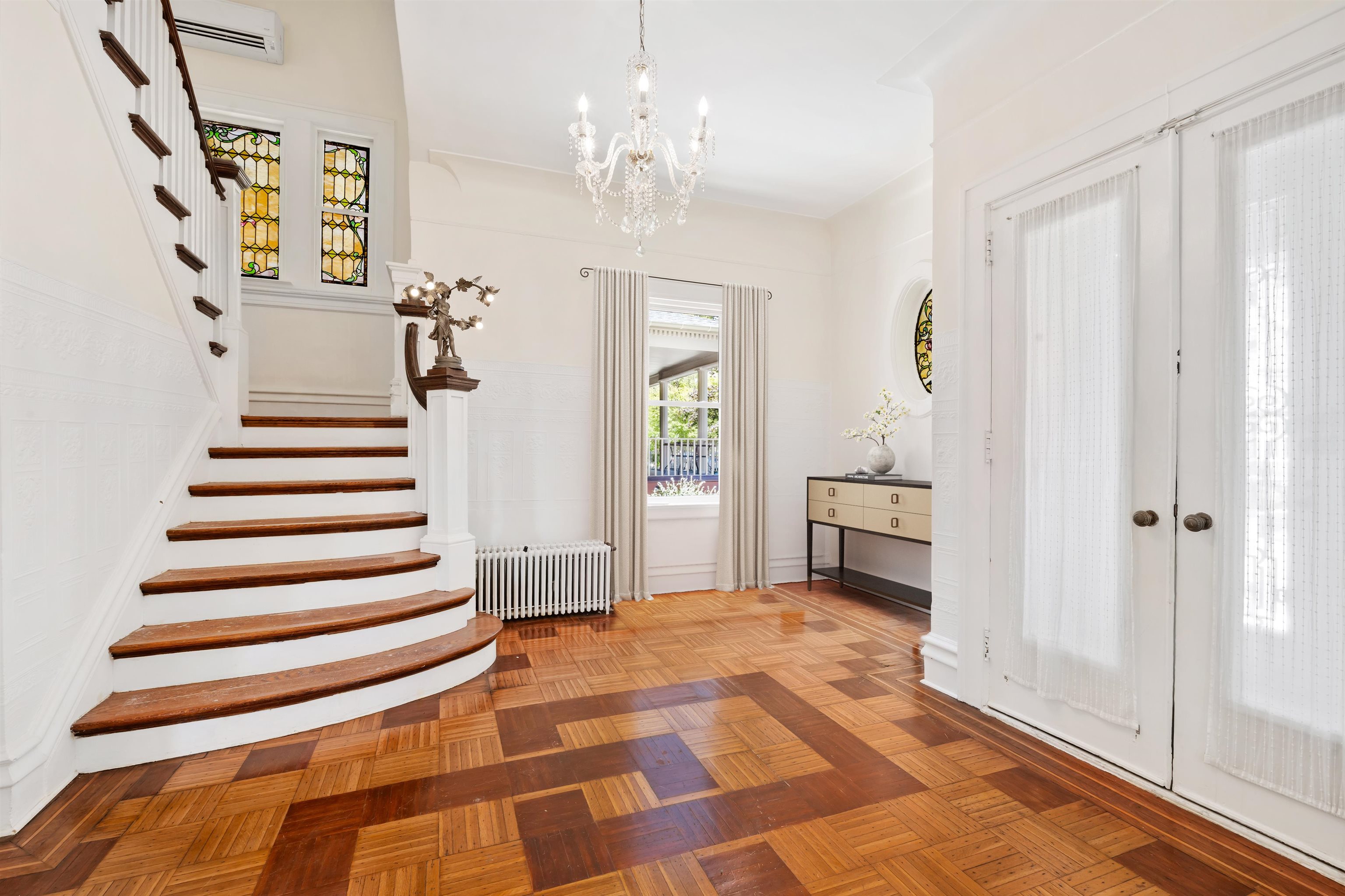 a view of a hallway with wooden floor and staircase