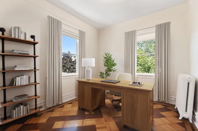 a view of a workspace with furniture and a window