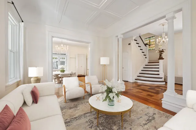 a living room with furniture and a dining table with wooden floor