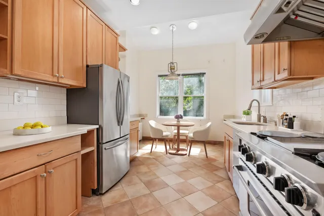 a kitchen with stainless steel appliances a stove a sink a refrigerator and cabinets
