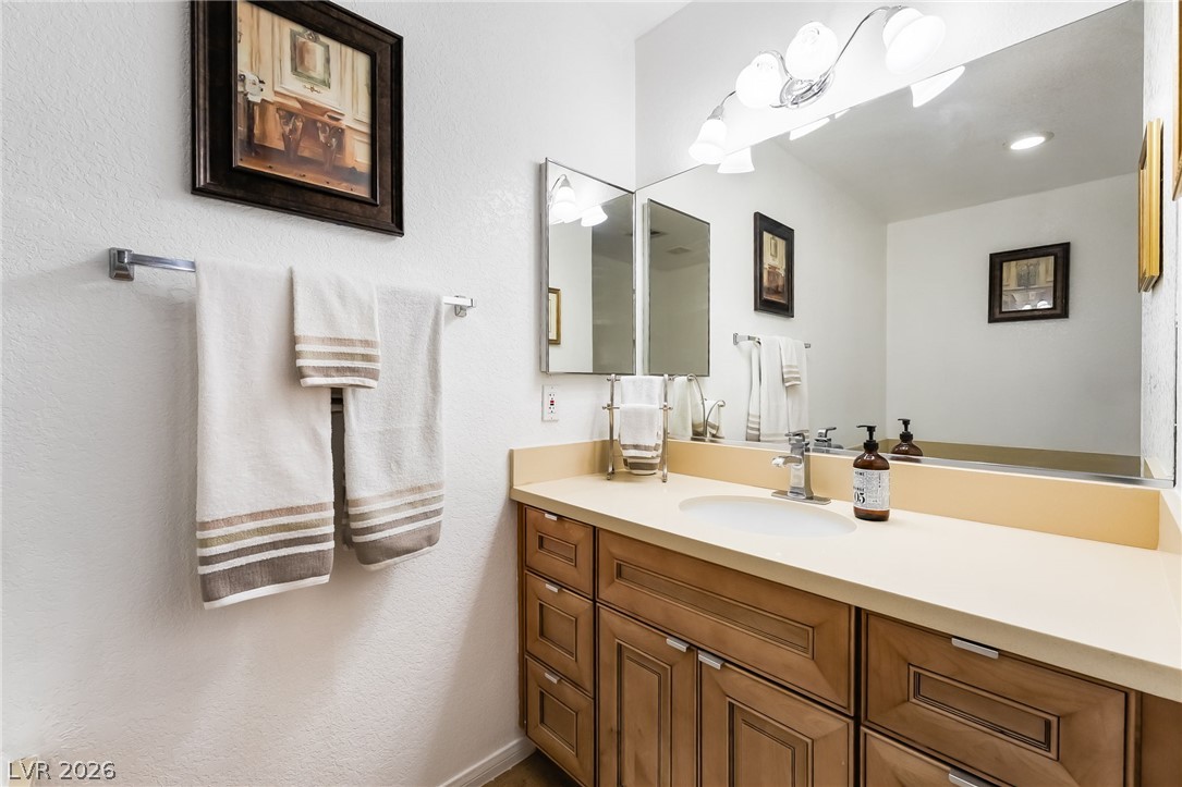 3631 South Blagg Road Pahrump, NV 89048 - Photo 23 of 47 A well-appointed bathroom features a light-colored countertop and wooden cabinetry with sleek hardware.
