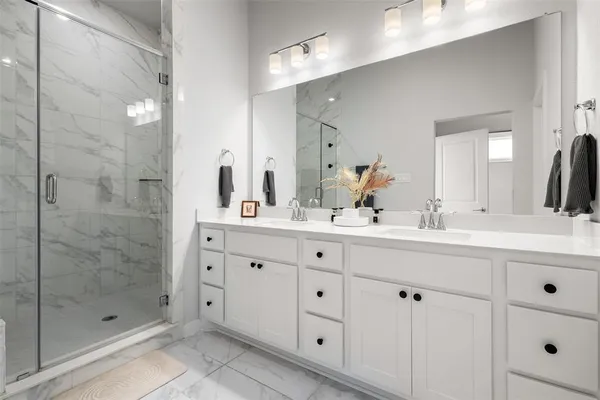 a bathroom with double sink and a mirror