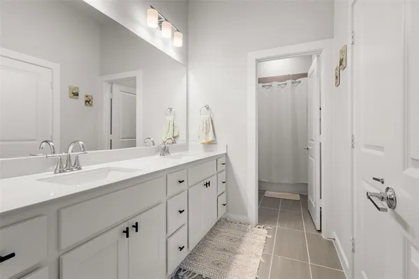 a spacious bathroom with double sink and a mirror