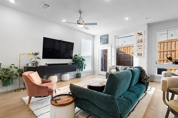 a living room with furniture a flat screen tv and a large window