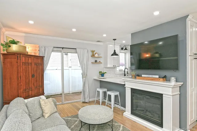 a room with a flat screen tv a sink and a mirror