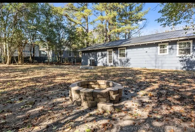 a backyard of a house with table and chairs