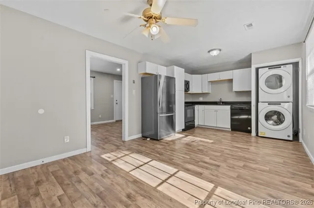 a view of a kitchen with a sink and dishwasher a refrigerator with wooden floor