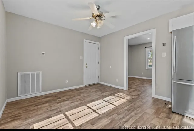 a view of a room with a stylish ceiling fan and entryway