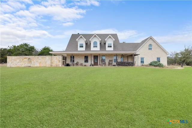 a view of a house with a big yard and large trees