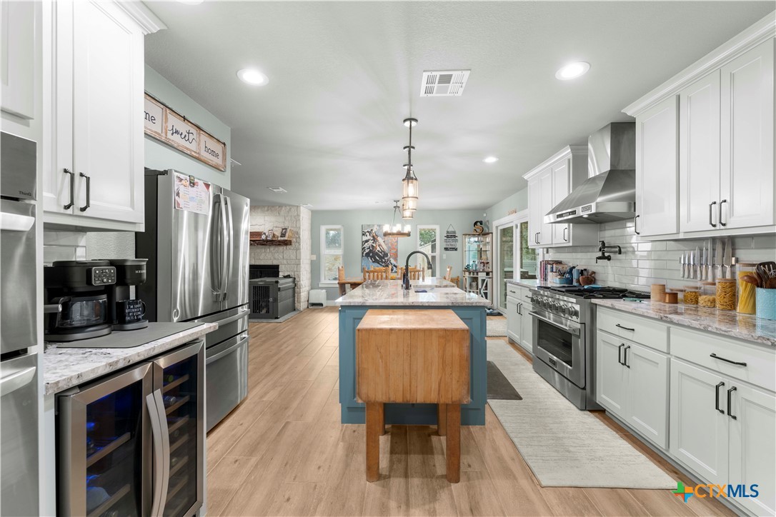 8901 Brewer Lane Salado, TX 76571 - Photo 15 of 30 a large kitchen with stainless steel appliances kitchen island granite countertop a lot of counter space and wooden floors