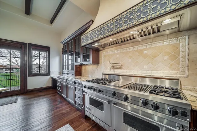 a kitchen with stainless steel appliances granite countertop a stove and a wooden floors