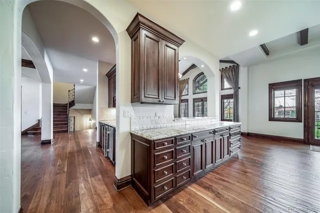 a kitchen with stainless steel appliances granite countertop a stove and a wooden floors