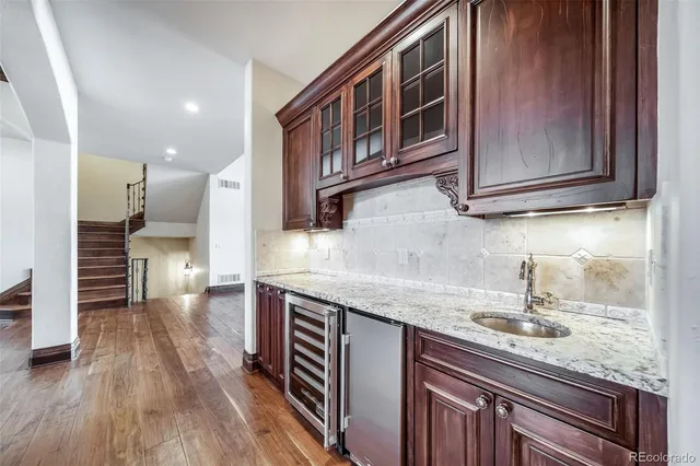 a kitchen with stainless steel appliances granite countertop a sink and wooden cabinets