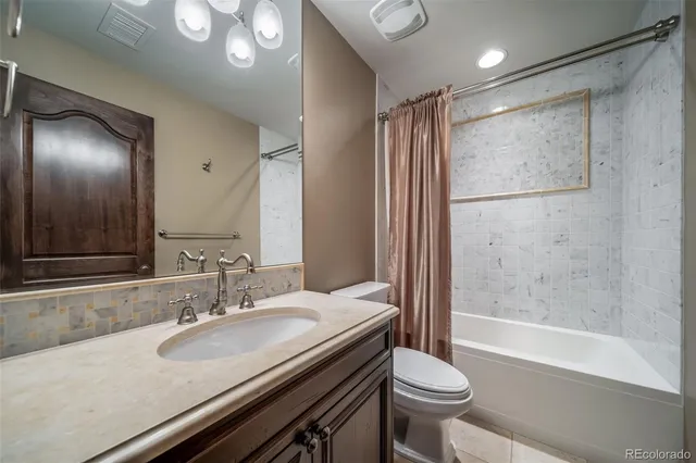 a bathroom with a granite countertop sink toilet and shower