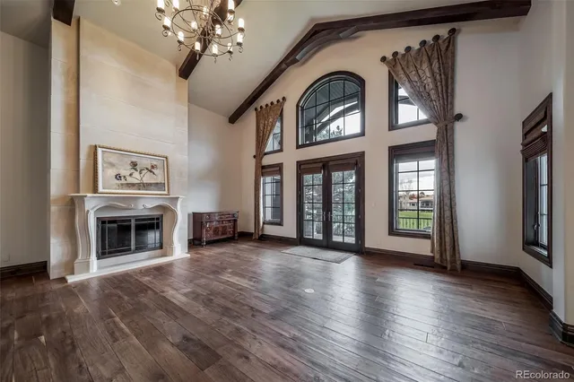 a view of a livingroom with a fireplace wooden floor chandelier