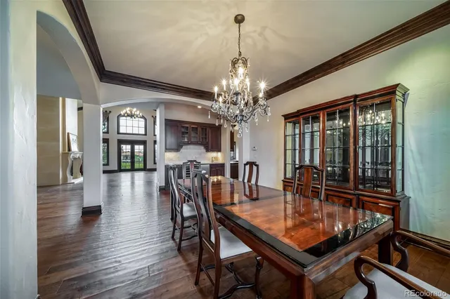 a dining room with furniture a chandelier and wooden floor