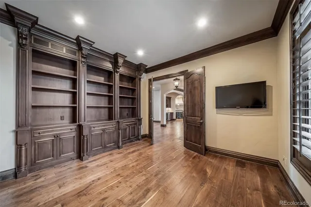 a view of a livingroom with an empty space & wooden floor