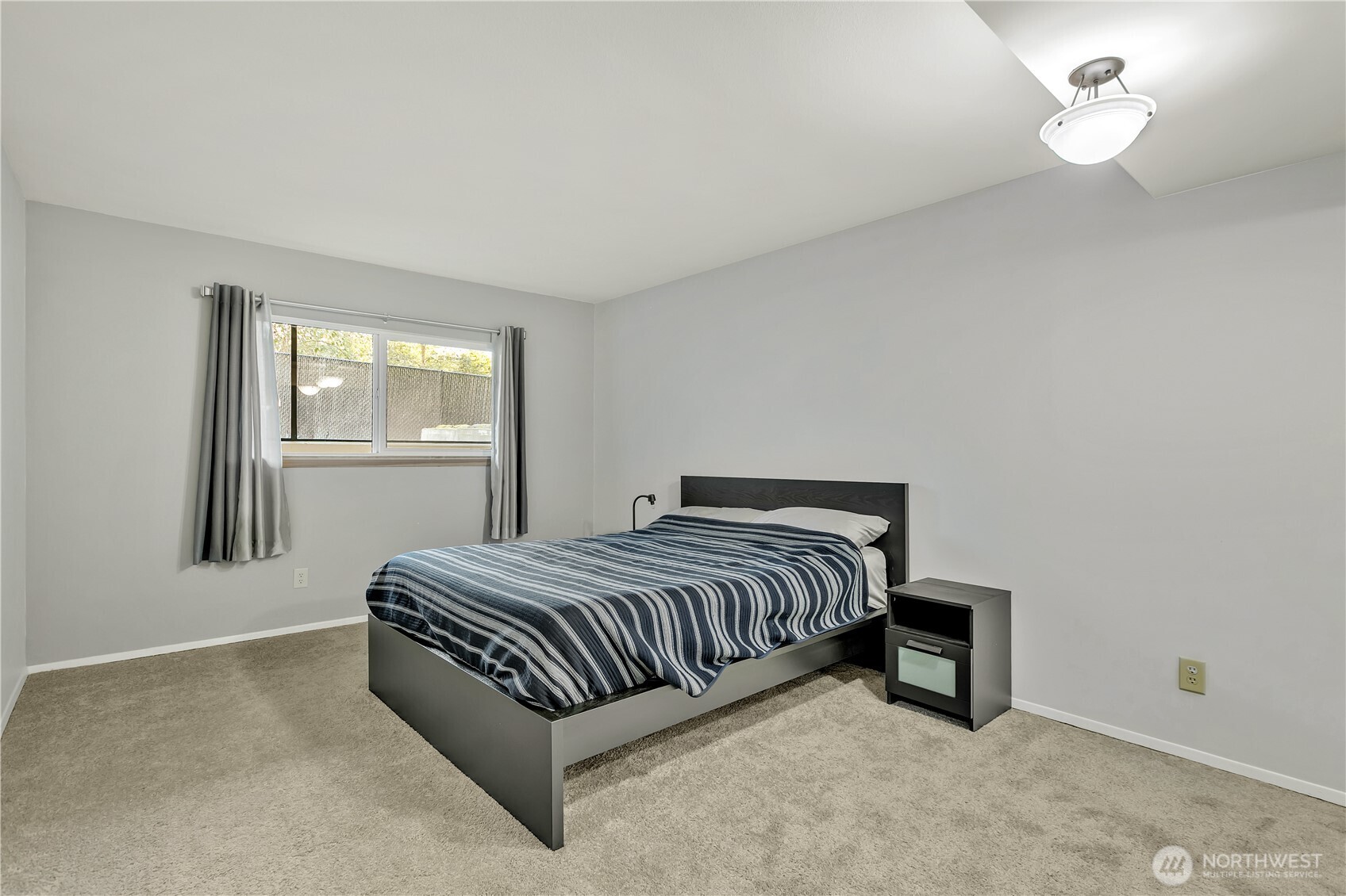 4545 Sand Point Way Northeast, Unit 207 Seattle, WA 98105 - Photo 18 of 25 a spacious bedroom with a bed and a window