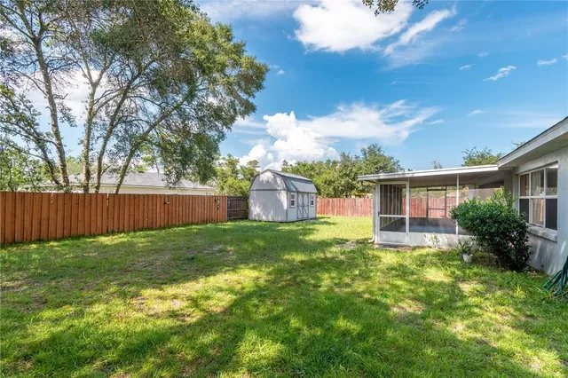 an aerial view of residential houses with outdoor space and trees