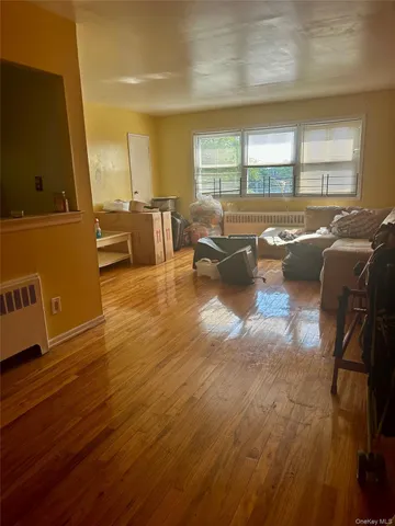 a living room with couches and kitchen view with wooden floor