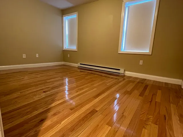 a view of a room with wooden floor and fan