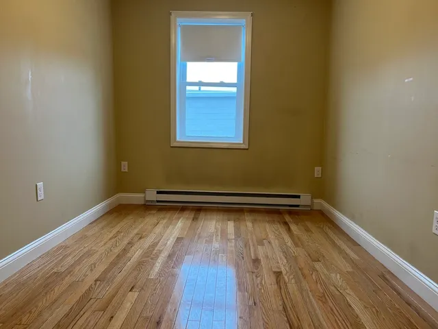a view of a room with wooden floor and a window