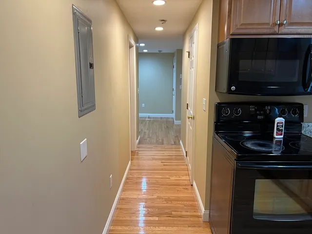 a view of a hallway with wooden floor and staircase