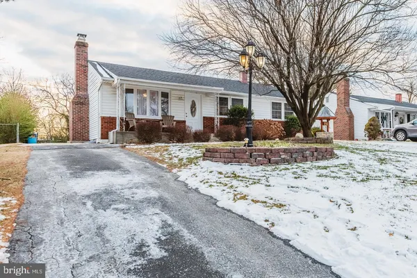 a front view of a house with a yard covered in snow