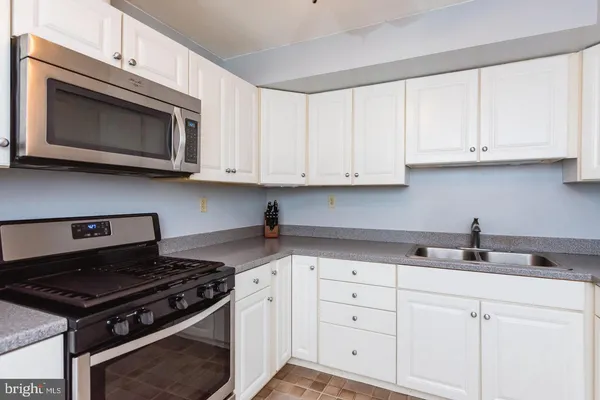 a kitchen with cabinets stainless steel appliances and a sink