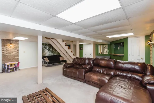 a view of a patio with couches table and chairs under an umbrella