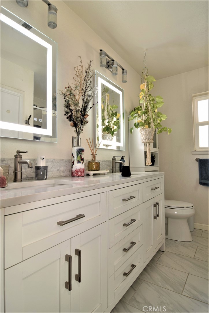 39334 Willowvale Road Palmdale, CA 93551 - Photo 16 of 21 a bathroom with a granite countertop sink a potted plant and a window