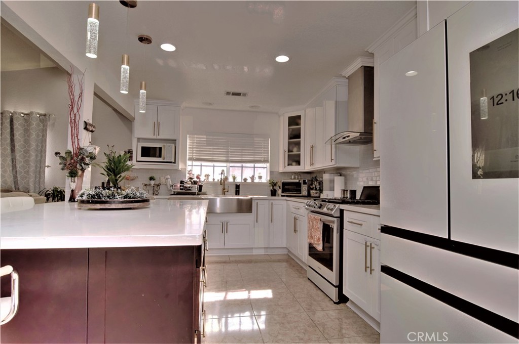 39334 Willowvale Road Palmdale, CA 93551 - Photo 6 of 21 a kitchen with stainless steel appliances kitchen island granite countertop a stove a sink and a refrigerator