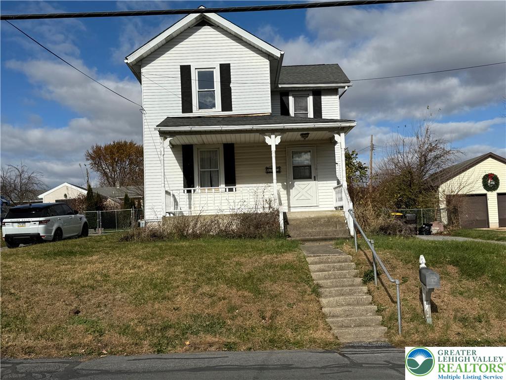A classic two-story residence with a charming front porch invites you home.