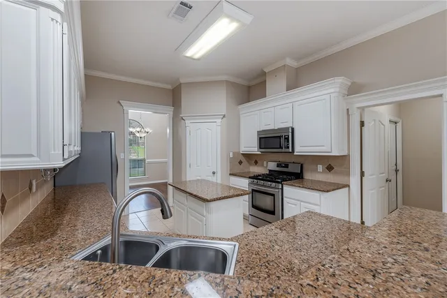 a kitchen with stainless steel appliances granite countertop a sink stove and refrigerator