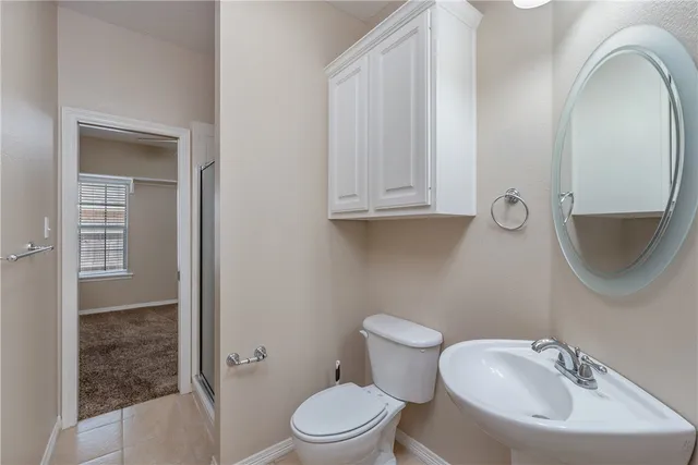 a bathroom with a toilet a sink and mirror