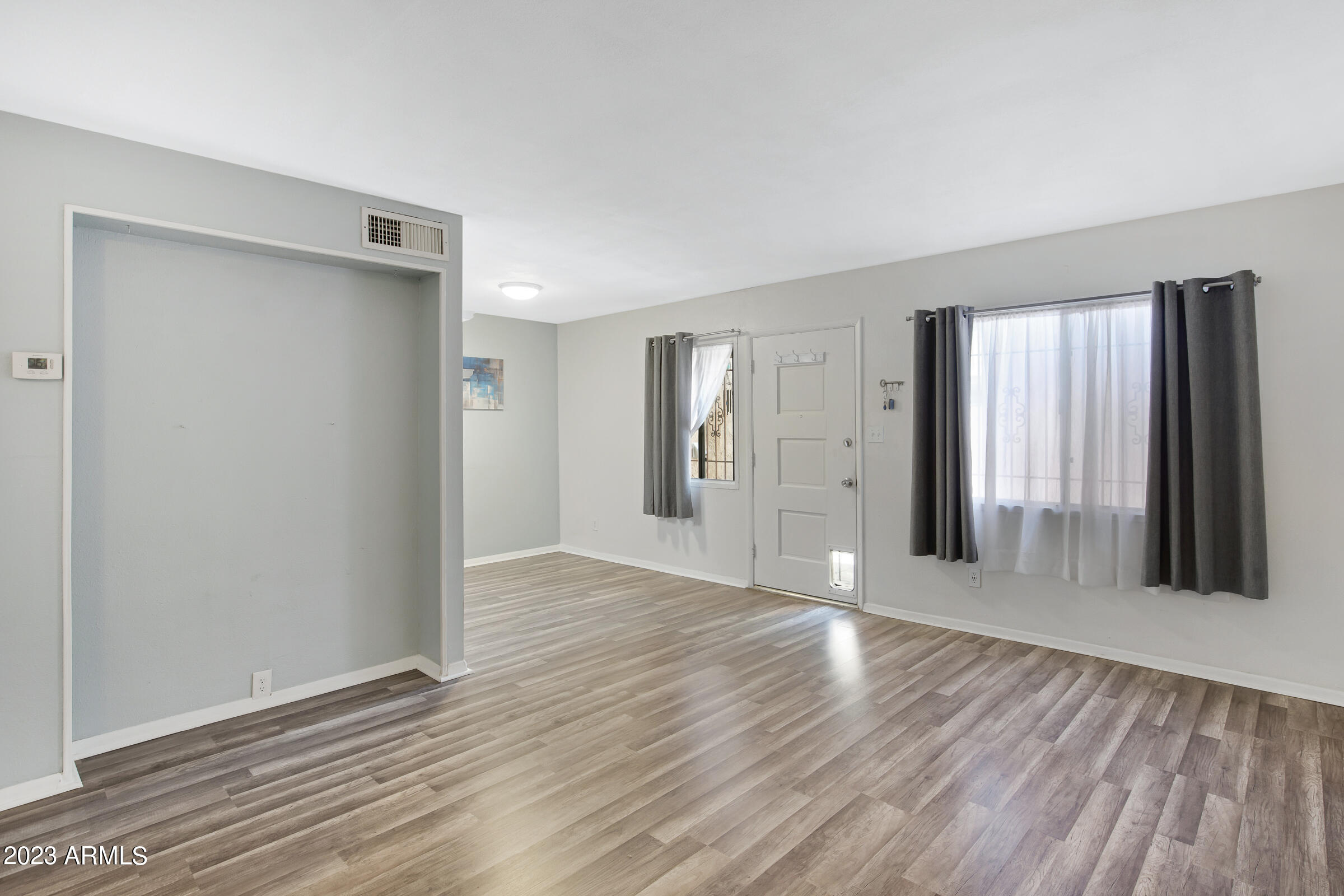 948 South Alma School Road, Unit 147 Mesa, AZ 85210 - Photo 7 of 22 a view of an empty room with wooden floor and a window