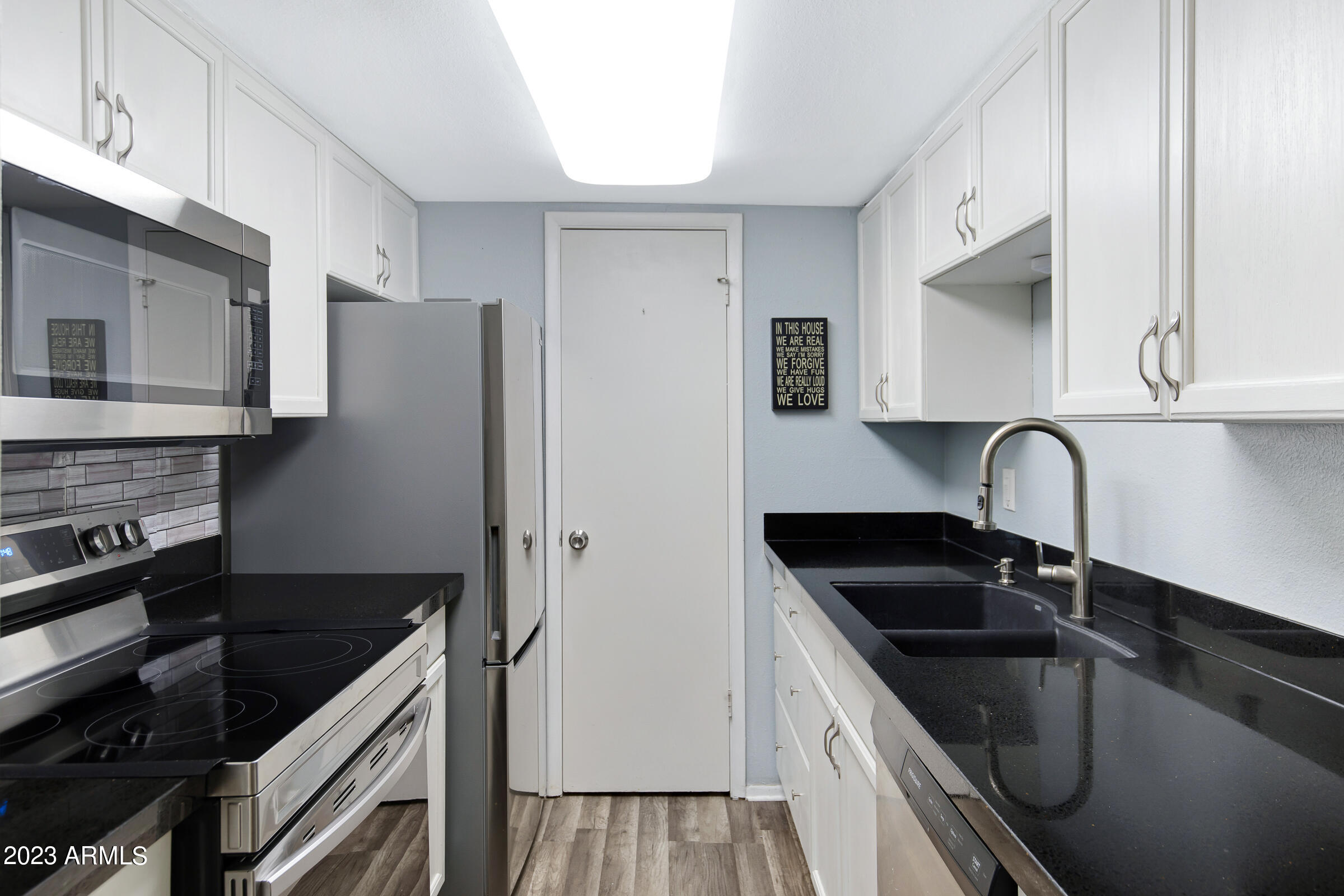 948 South Alma School Road, Unit 147 Mesa, AZ 85210 - Photo 9 of 22 a kitchen with granite countertop a refrigerator and a sink