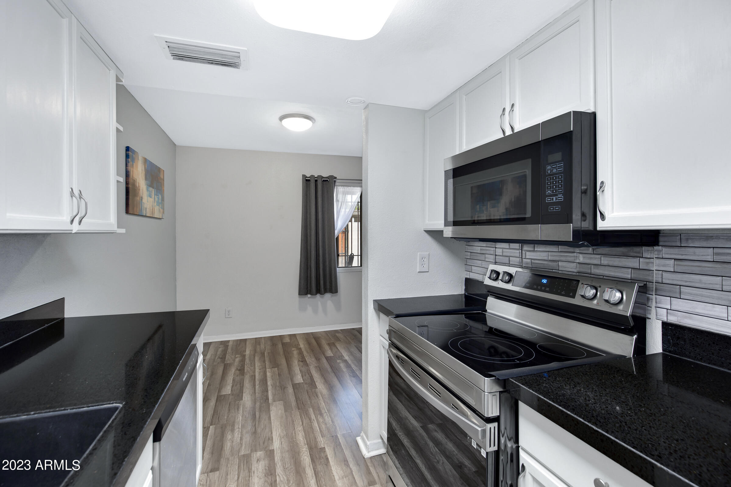 948 South Alma School Road, Unit 147 Mesa, AZ 85210 - Photo 10 of 22 a kitchen with a stove and a microwave