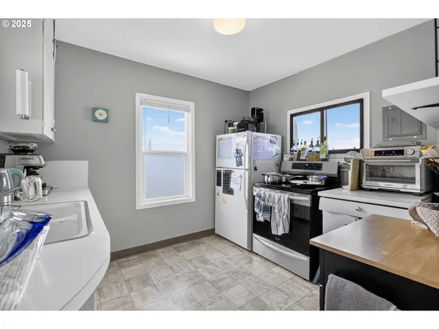 a kitchen with a refrigerator and a stove top oven