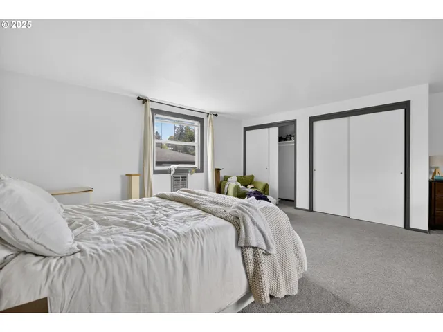 a bedroom with a bed and a large mirror