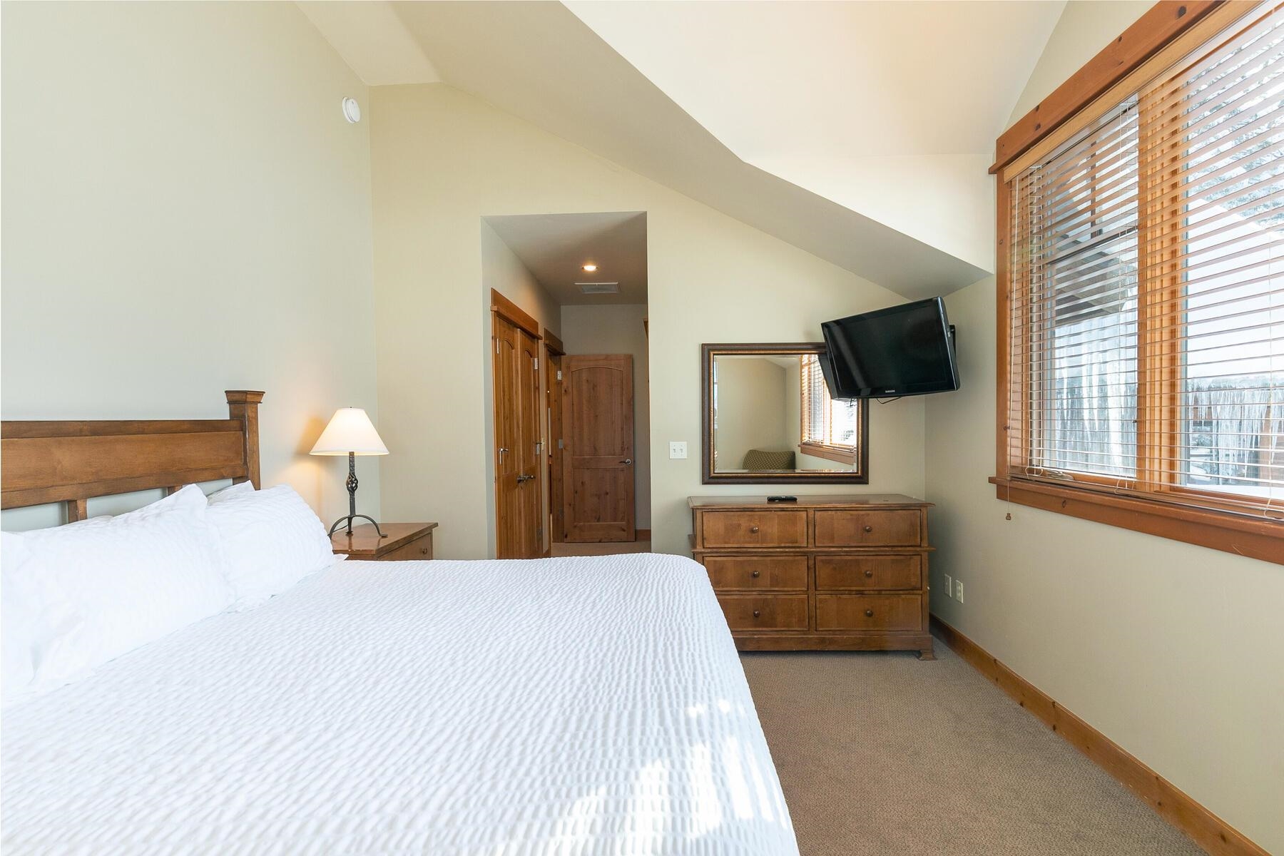 12229 Lookout Loop, Unit F513 Truckee, CA 96161 - Photo 17 of 28 a bedroom with a large bed and a flat tv screen on dresser