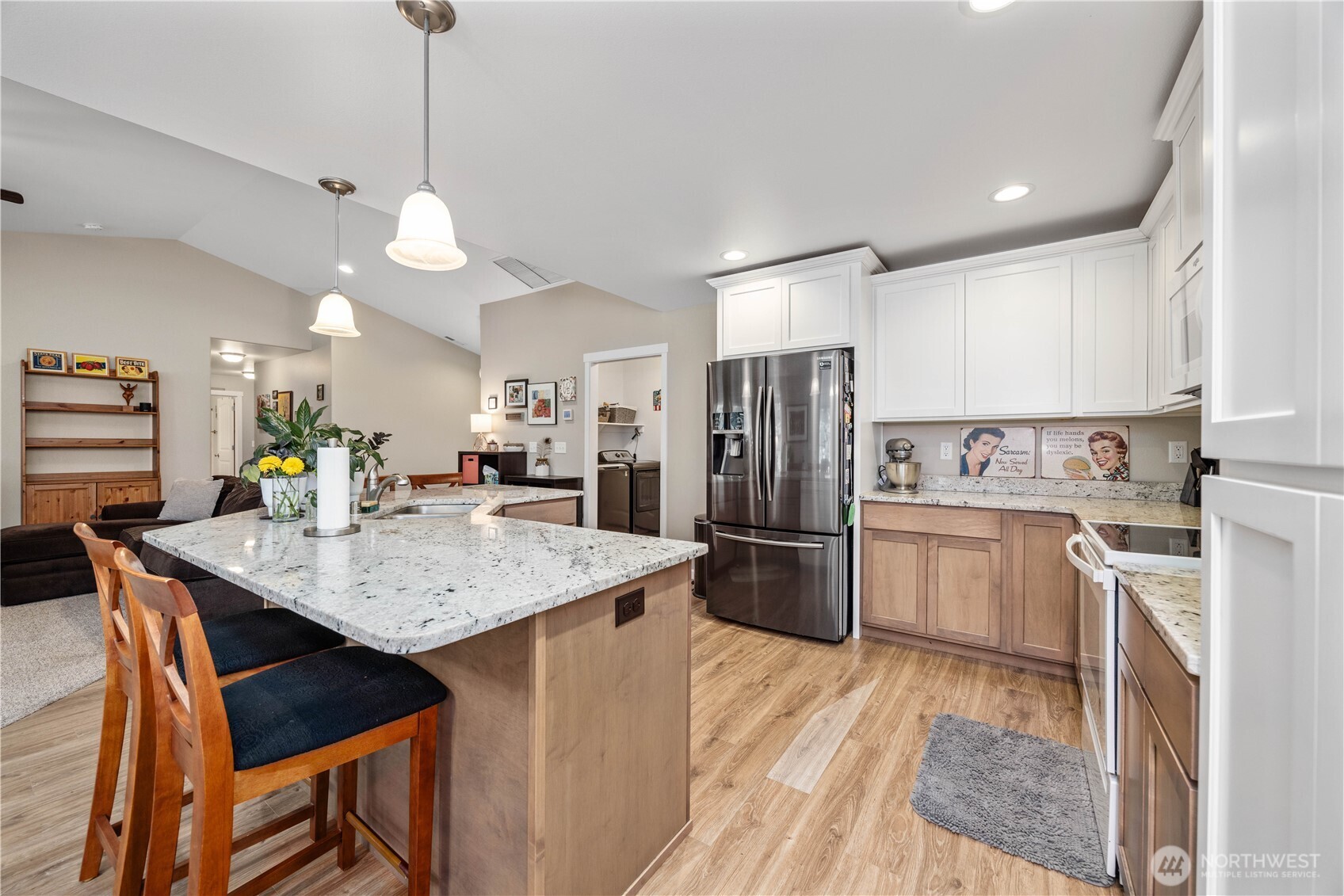 479 Spring View Place Chelan, WA 98816 - Photo 8 of 37 a kitchen with stainless steel appliances kitchen island a refrigerator a stove a sink dishwasher a dining table and chairs with wooden floor