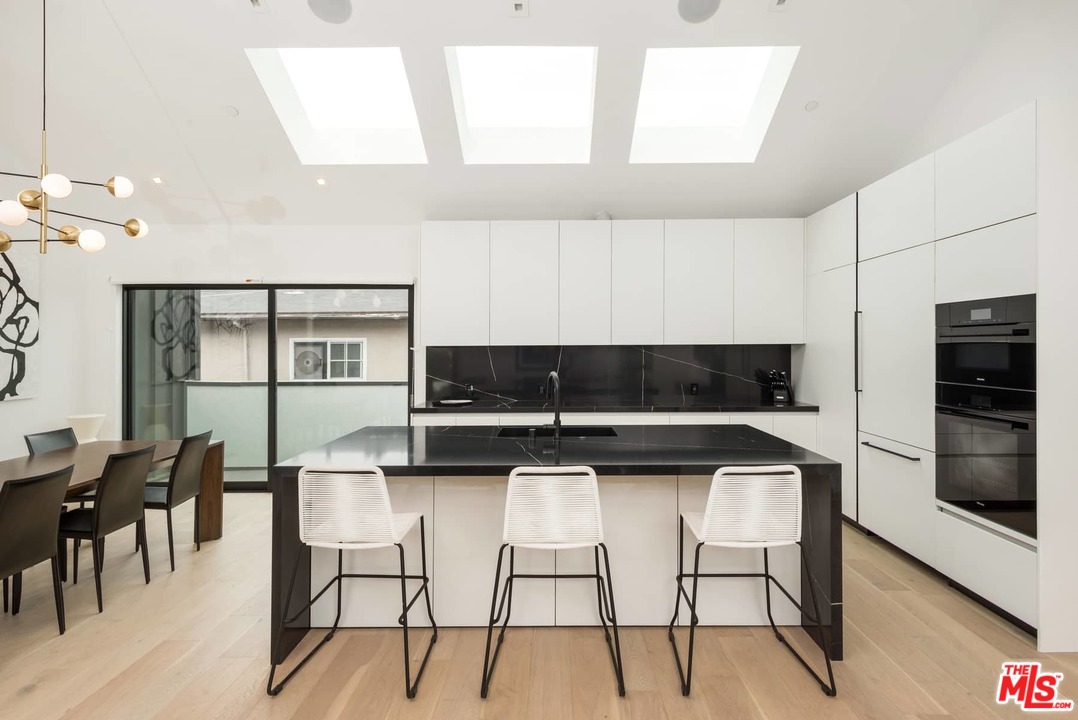 629 Sunset Avenue Venice, CA 90291 - Photo 12 of 31 a kitchen with stainless steel appliances kitchen island a table chairs in it and wooden floors
