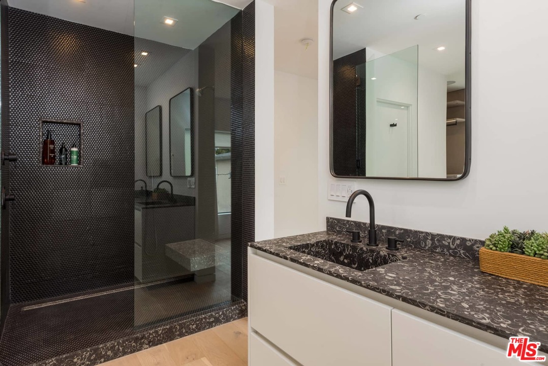 629 Sunset Avenue Venice, CA 90291 - Photo 16 of 31 a bathroom with a granite countertop sink a mirror and shower