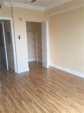 1830 Radius Drive, Unit 1003 Hollywood, FL 33020 - Photo 7 of 12 a view of an empty room with wooden floor and a window