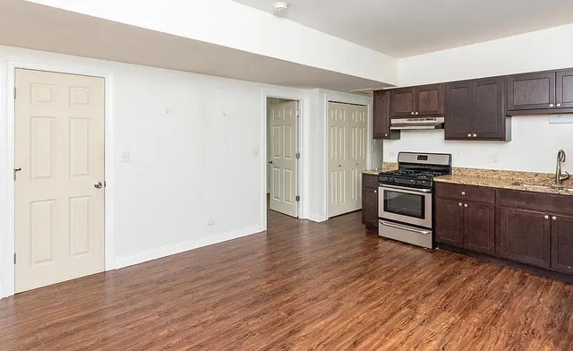 a kitchen with wooden floors and stainless steel appliances